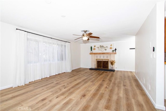 57825 El Dorado Dr, Yucca Valley, CA 92284 - unfurnished living room featuring ceiling fan, light wood-type flooring, and a brick fireplace