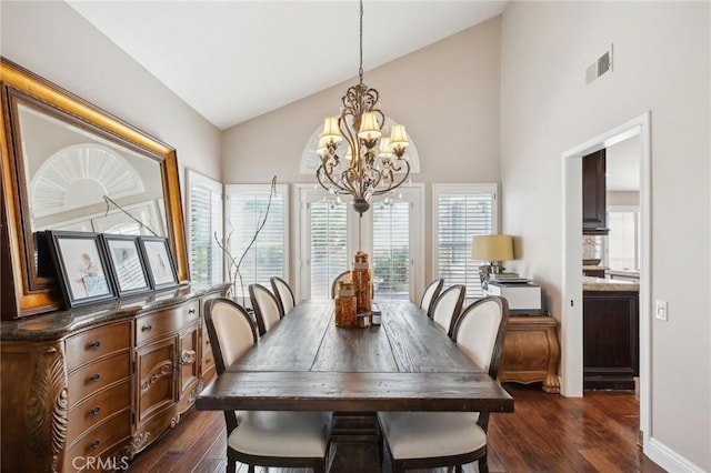 dining space with dark hardwood / wood-style flooring, high vaulted ceiling, and a notable chandelier