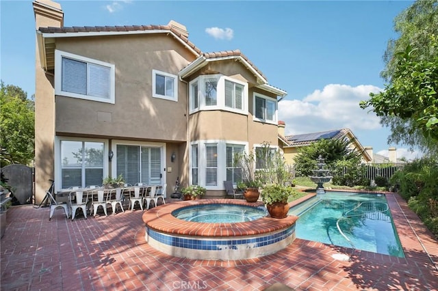 rear view of house featuring a fenced in pool and a patio area