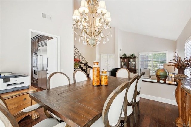 dining room featuring dark hardwood / wood-style flooring, an inviting chandelier, and high vaulted ceiling