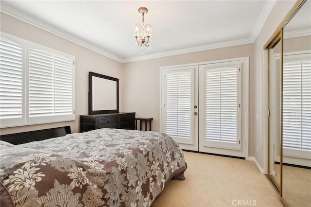 carpeted bedroom with a closet, ornamental molding, and a chandelier