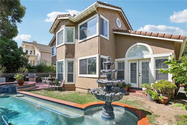 rear view of property with french doors and a patio