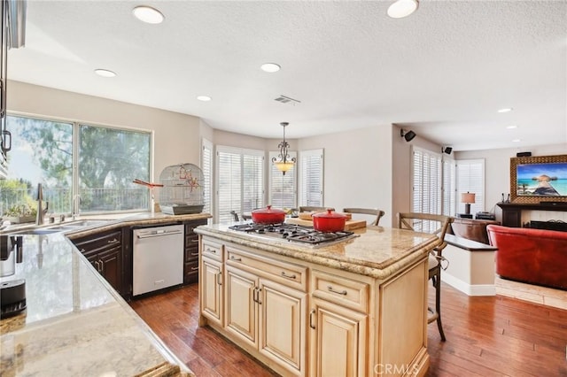 kitchen with a breakfast bar, white dishwasher, dark wood-type flooring, pendant lighting, and a center island