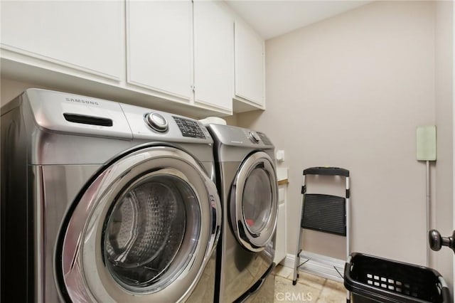 laundry room featuring washer and clothes dryer and cabinets