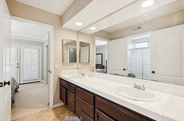 bathroom with tile patterned flooring, vanity, an enclosed shower, and crown molding