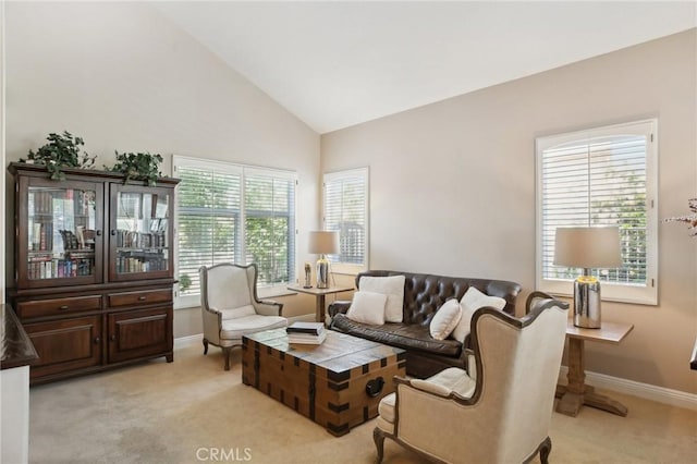 living room featuring plenty of natural light, light carpet, and high vaulted ceiling