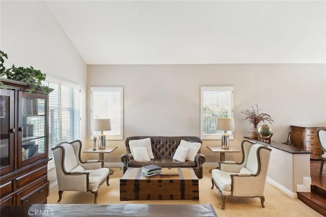 carpeted living room with plenty of natural light and vaulted ceiling