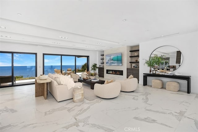 living room featuring a water view and a large fireplace