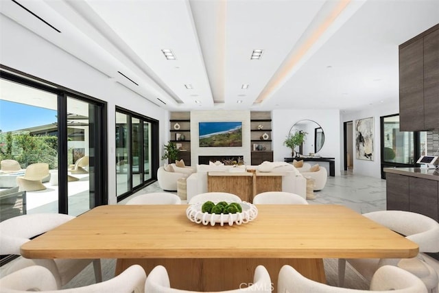 67 Monarch Bay Dr, Dana Point, CA 92629 - dining space with a fireplace, beam ceiling, marble finish floor, and built in shelves