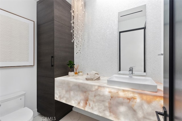 bathroom featuring a shower with door, vanity, and toilet