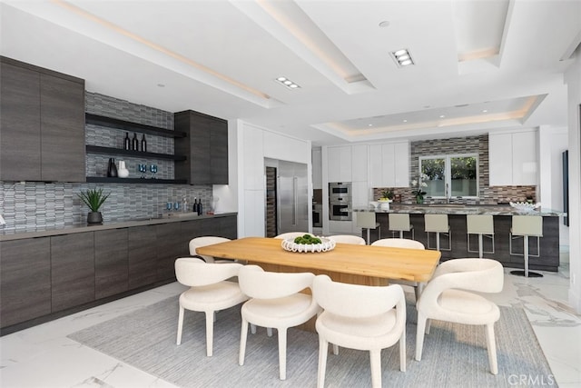 dining area with wet bar and a tray ceiling