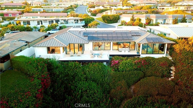 67 Monarch Bay Dr, Dana Point, CA 92629 - back of house featuring a residential view, roof mounted solar panels, a patio, and metal roof
