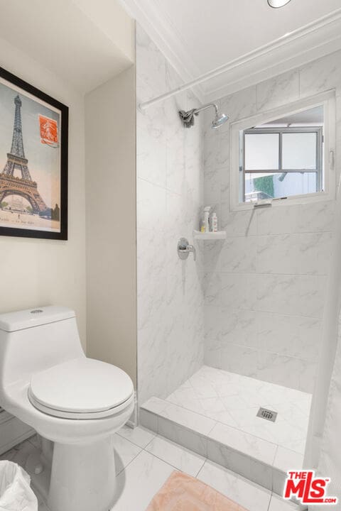 bathroom with crown molding, toilet, and a shower with shower curtain