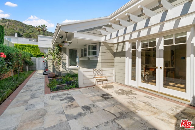 view of patio with a pergola, a mountain view, and french doors