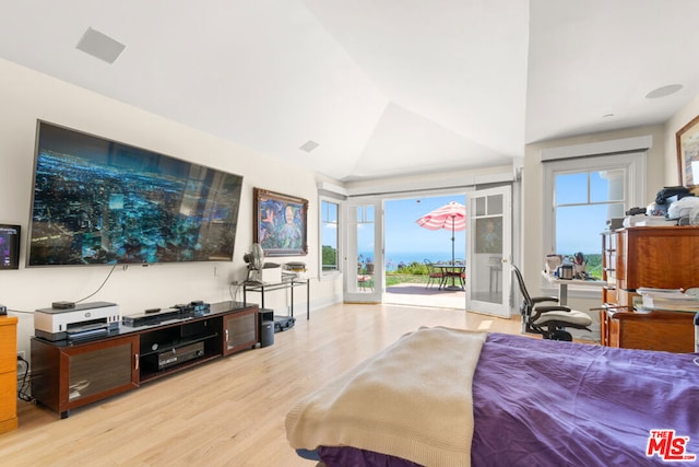 bedroom featuring access to exterior, lofted ceiling, and light hardwood / wood-style floors