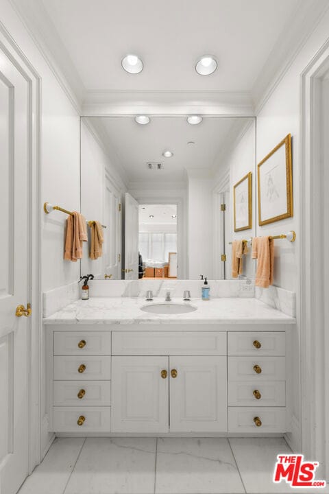 bathroom featuring ornamental molding and vanity