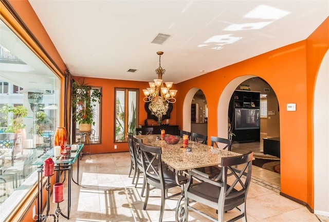 tiled dining room with a chandelier