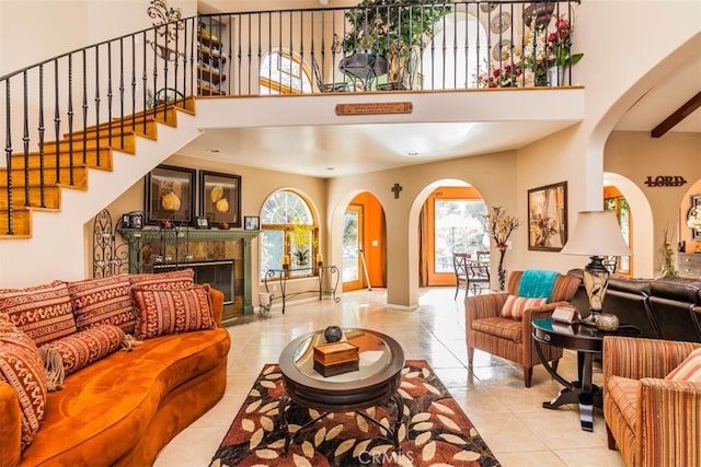 living room featuring a healthy amount of sunlight, beam ceiling, and light tile patterned floors