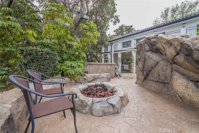 view of patio / terrace featuring a balcony and an outdoor fire pit