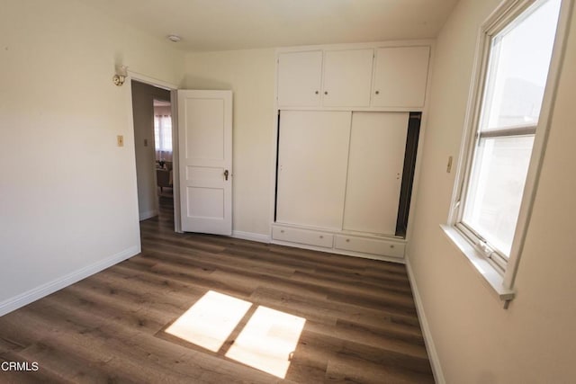 unfurnished bedroom featuring a closet and dark hardwood / wood-style flooring