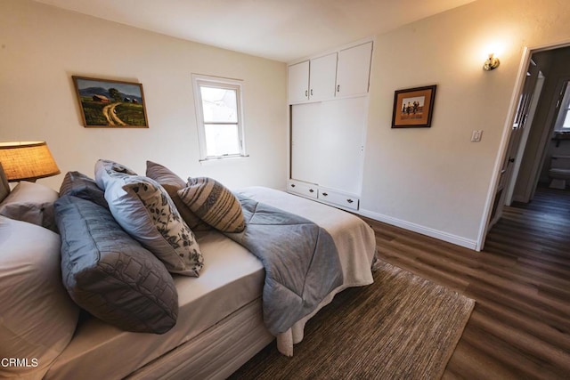 bedroom with dark hardwood / wood-style flooring