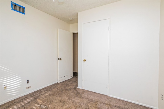 unfurnished bedroom featuring carpet and a textured ceiling