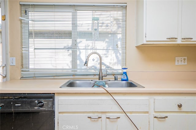 kitchen featuring sink, white cabinets, and black dishwasher