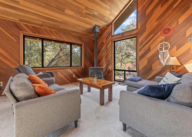 living room featuring wood ceiling, light carpet, a wood stove, vaulted ceiling, and wood walls