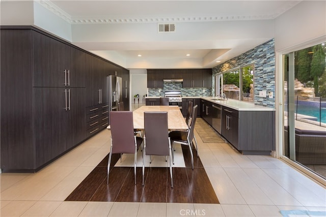 kitchen with a center island, sink, a breakfast bar area, stainless steel appliances, and backsplash