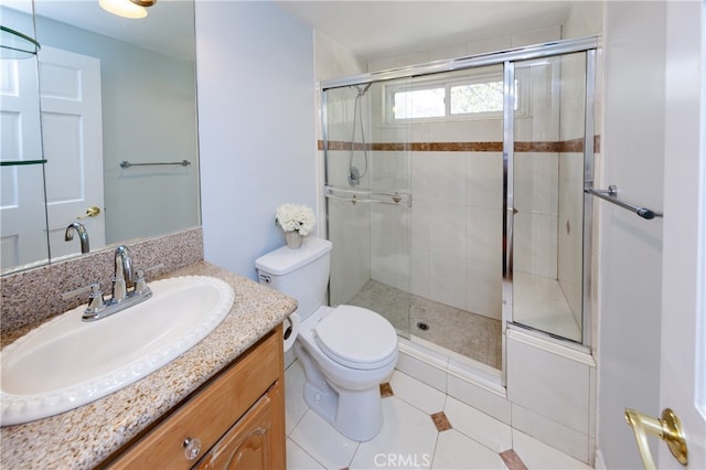 bathroom with vanity, a shower with shower door, toilet, and tile patterned flooring