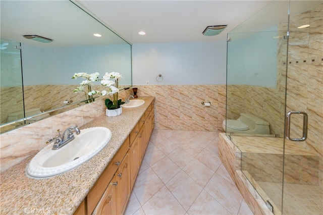 bathroom featuring tile walls, tile patterned flooring, walk in shower, and vanity