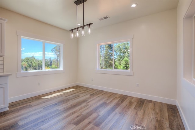 unfurnished dining area with light hardwood / wood-style flooring and a healthy amount of sunlight