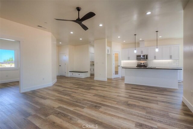 unfurnished living room with ceiling fan and light hardwood / wood-style floors