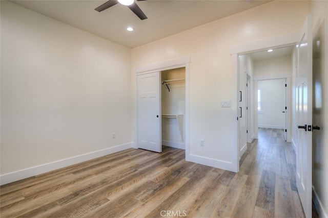 unfurnished bedroom featuring wood-type flooring, ceiling fan, and a closet