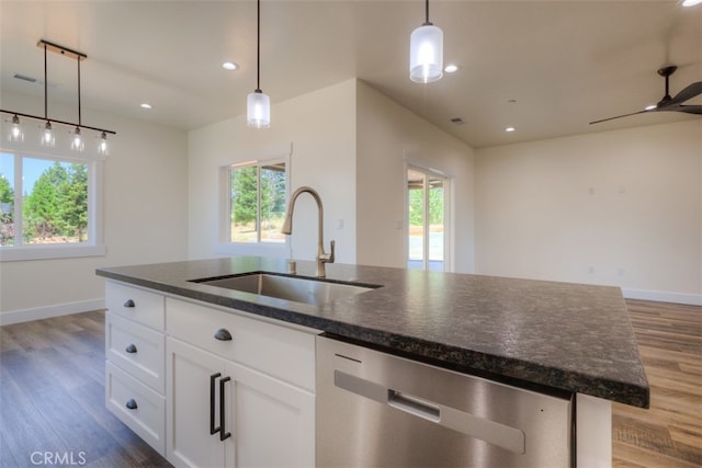 kitchen with white cabinets, a kitchen island with sink, dark wood-type flooring, dishwasher, and dark stone counters