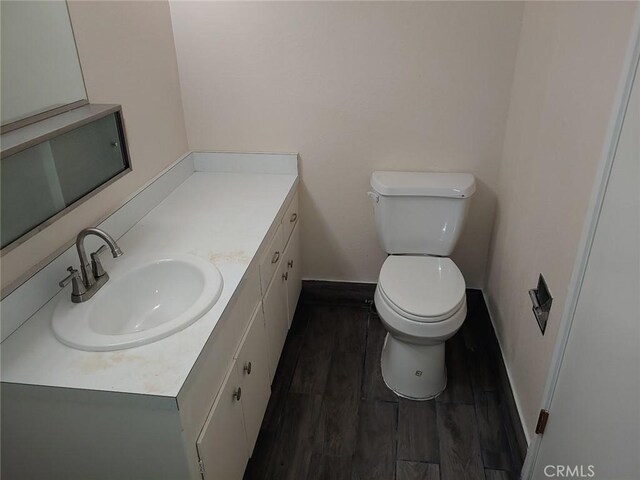 bathroom featuring vanity, hardwood / wood-style floors, and toilet