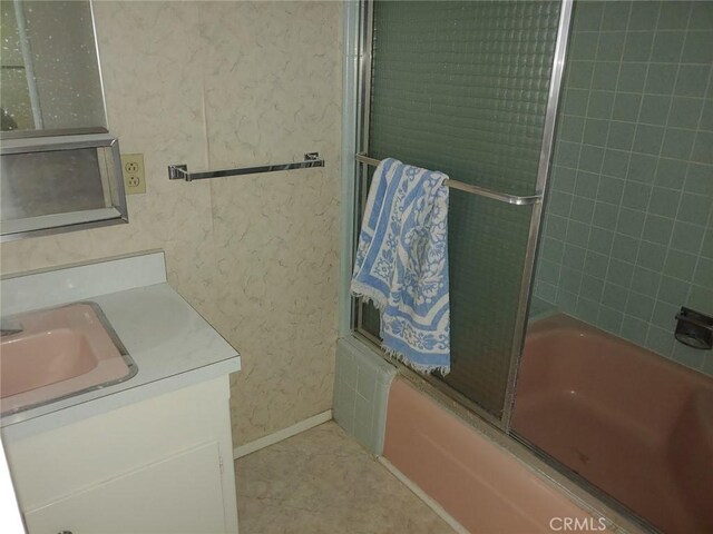 bathroom featuring bath / shower combo with glass door and vanity