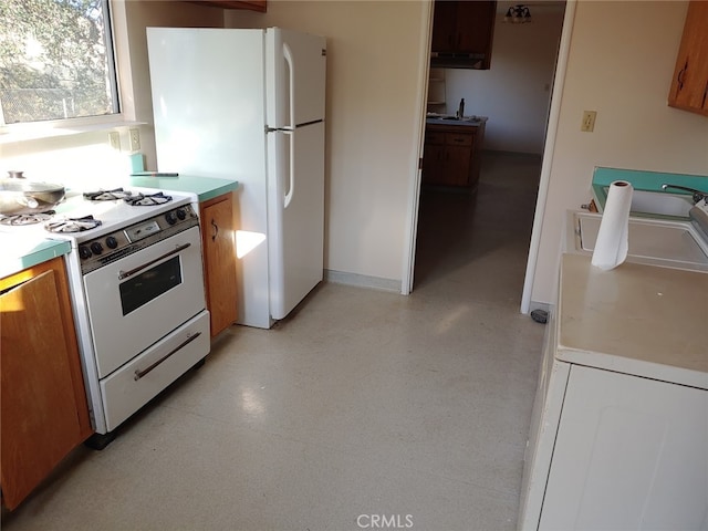 kitchen featuring washer / clothes dryer and white appliances