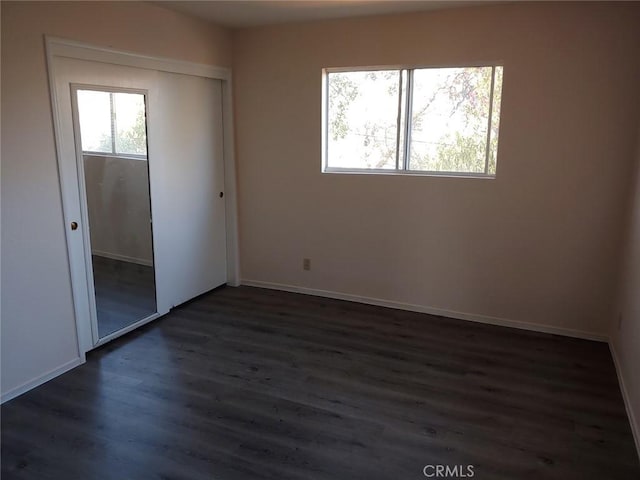 13050 Carter Ln Unit 1, Clearlake, CA 95422 - unfurnished bedroom with dark wood finished floors, a closet, baseboards, and multiple windows