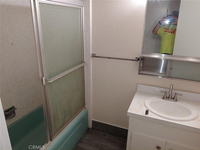 bathroom featuring vanity, shower / bath combination with glass door, and hardwood / wood-style floors