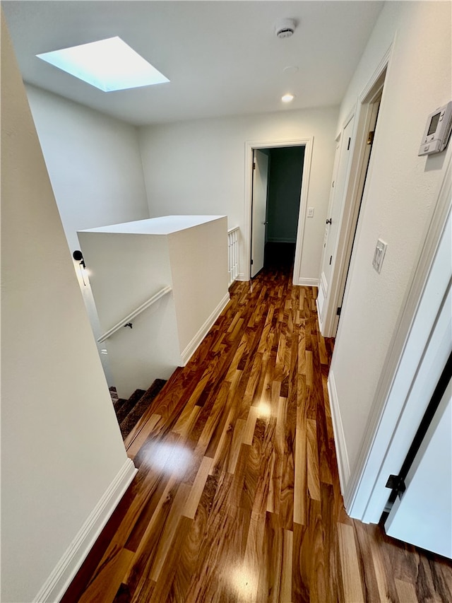 hall featuring a skylight and dark hardwood / wood-style flooring