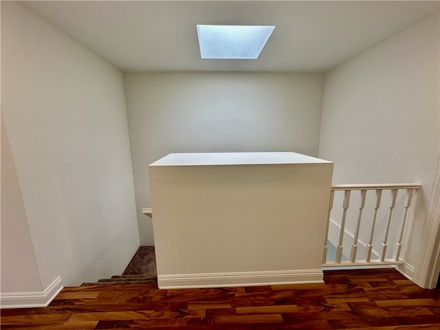 stairs featuring a skylight and hardwood / wood-style flooring