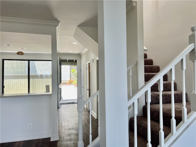 stairs with wood-type flooring and crown molding