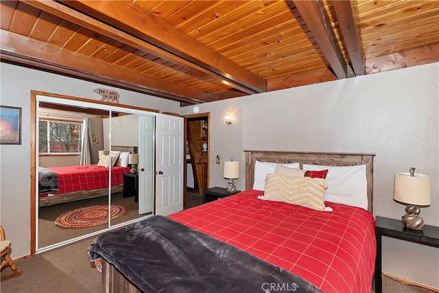 bedroom featuring a closet, beam ceiling, wooden ceiling, and carpet floors