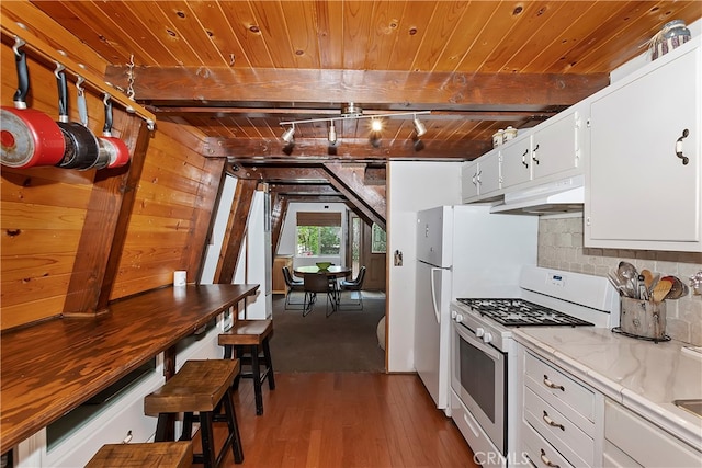 kitchen with backsplash, gas range gas stove, white cabinets, light hardwood / wood-style floors, and wood walls