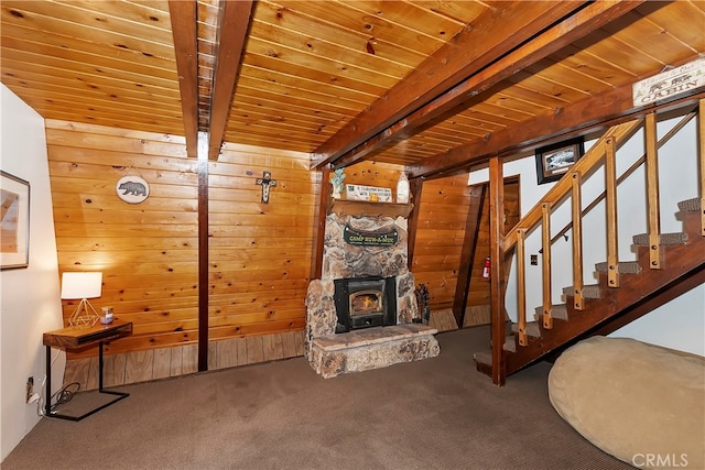 unfurnished living room with wood walls, carpet floors, beam ceiling, and wooden ceiling