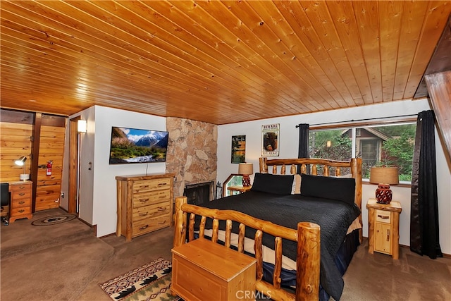 carpeted bedroom featuring wood ceiling, a stone fireplace, and wooden walls