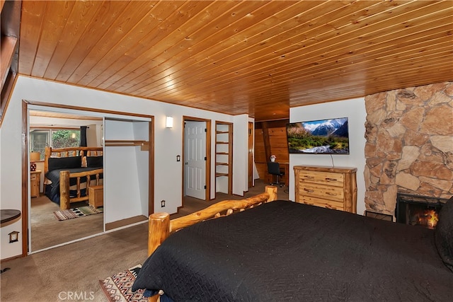 carpeted bedroom featuring wood ceiling and a fireplace