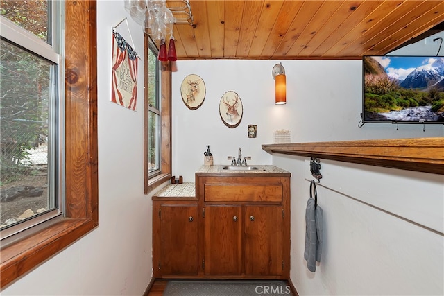 interior space featuring vanity, wood ceiling, and ornamental molding