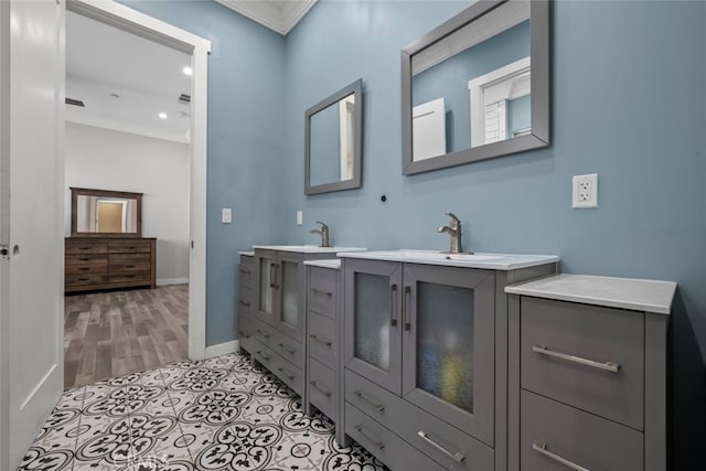 bathroom with crown molding, hardwood / wood-style floors, and vanity